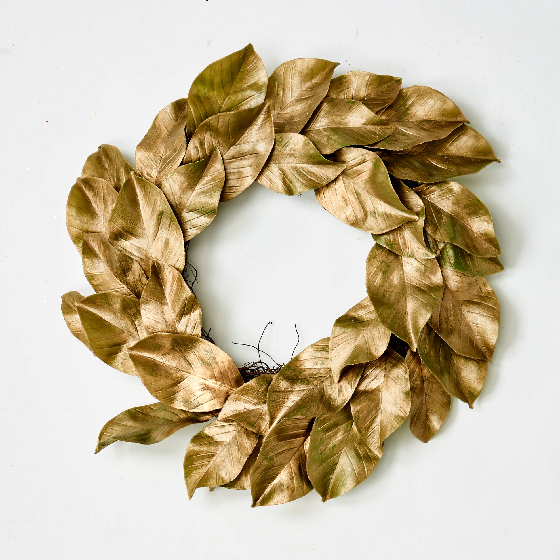 A 22" Magnolia Leaves Wreath made of layered dried golden-brown magnolia leaves in a circular arrangement.