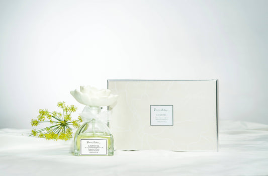 Clear diffuser bottle with white ceramic flower cap and matching box. Available in standard and gift set sizes.