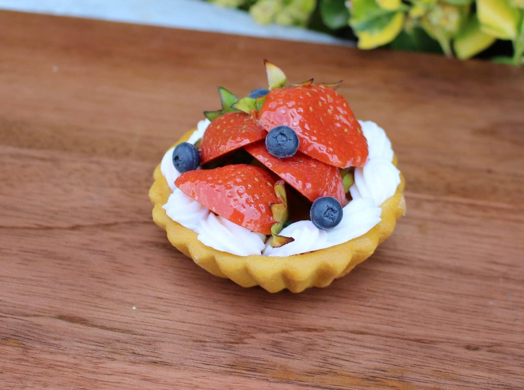 Fake Mini Strawberry &amp; Blueberry Tart replica with cream, sliced strawberries, and blueberries. Available in small and medium sizes.