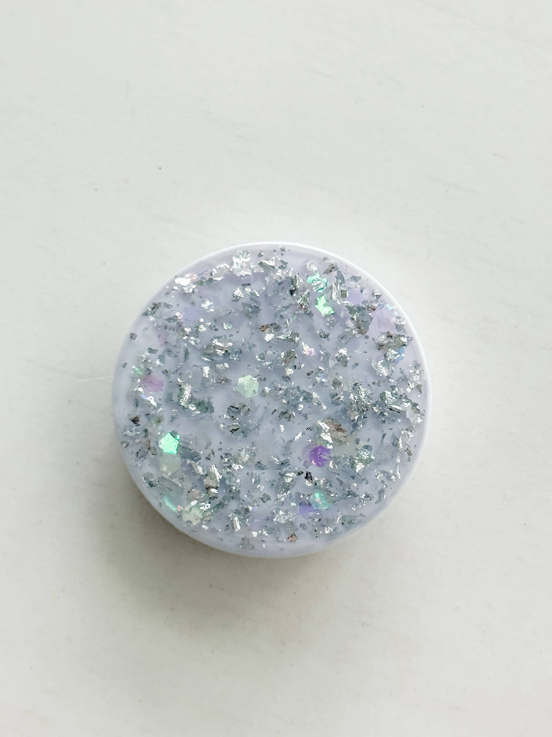 The Glitz and Glam "Silver" Phone Grip: round, white lid with silver and iridescent glitter; available in standard sizes.