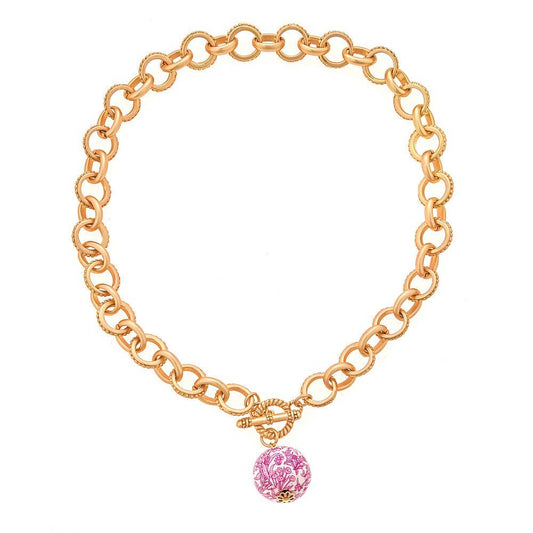 17" gold chain necklace with circular links, toggle clasp, and central pink floral-patterned bead. Available in 17".