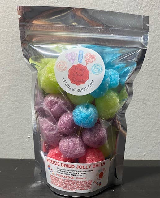 Clear pouch labeled "FREEZE DRIED JOLLY BALLS" with colorful, round freeze dried candy in blue, green, purple, and pink; sizes available.