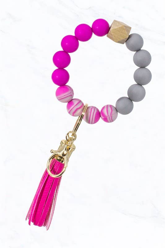 Tie Dye Silicone Beaded Key Ring with pink, gray, marbled beads, wood accent, gold clasp, and pink tassel. Sizes: not specified.