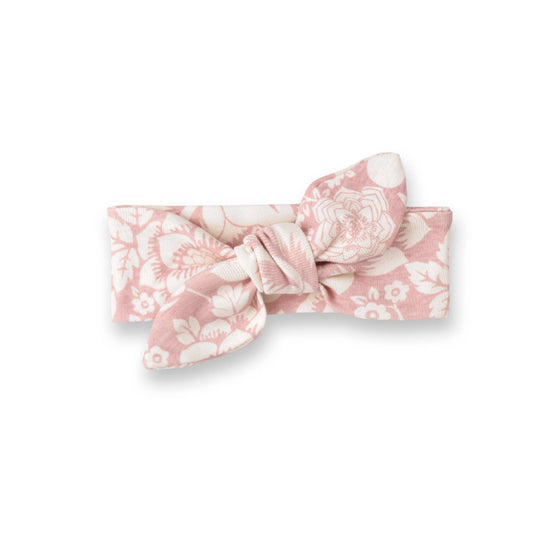 Knotted headbank with pink base and white floral pattern.