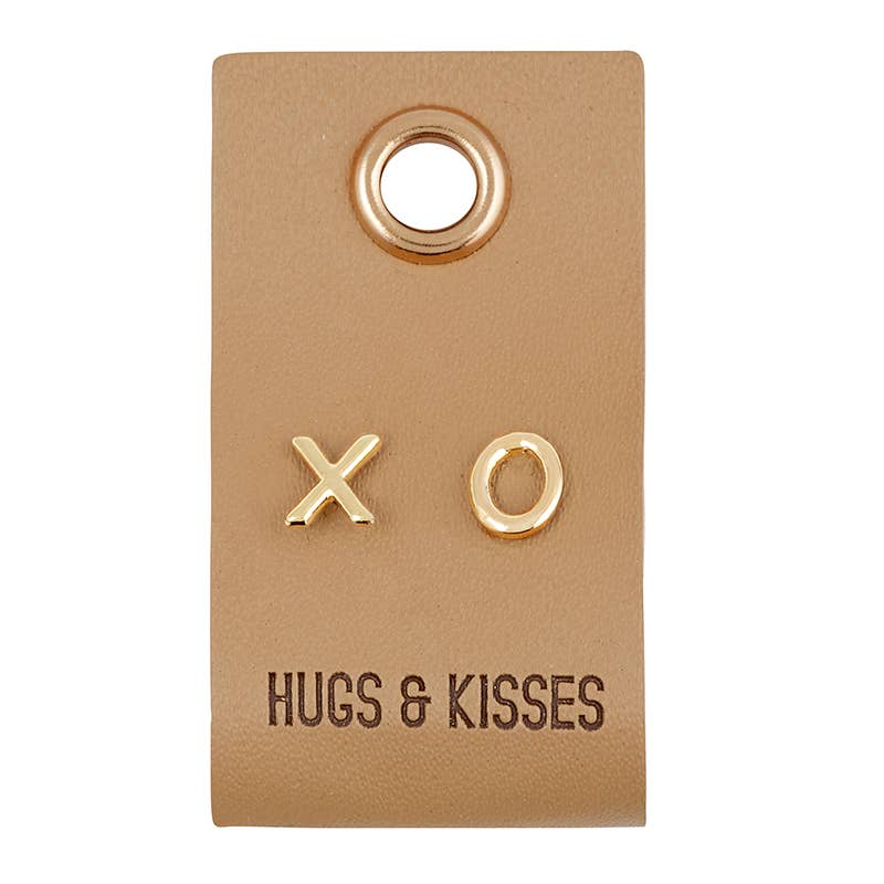XO-shaped gold stud earrings on leather tag, style F3900. "HUGS &amp; KISSES" printed. Sizes available: S, M, L.