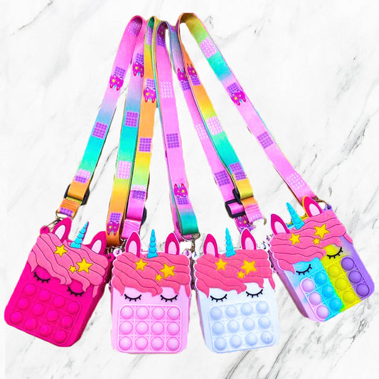 Unicorn-shaped silicone Pop it purses with rainbow straps in pink, purple, or blue. Available sizes: small and medium.
