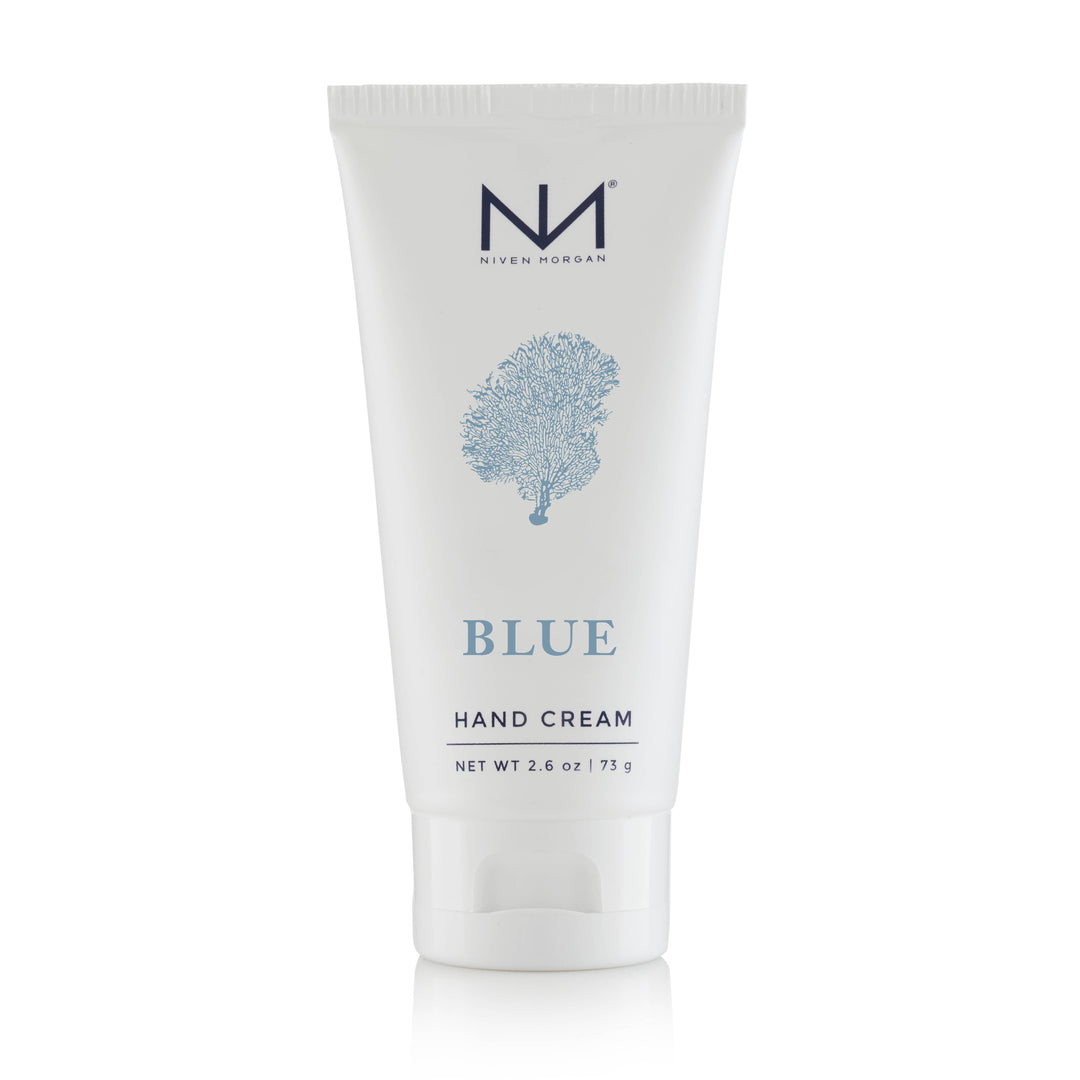 This 2.6 oz tube of Blue Travel Hand Cream infuses the nourishing properties of organic aloe vera. The packaging presents in a clean white color, embellished with a charming blue coral design, and is visibly labeled "Blue Hand Cream.