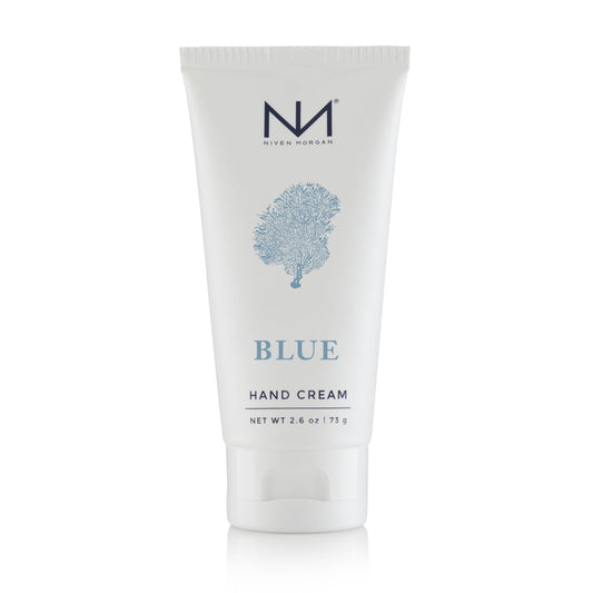 This 2.6 oz tube of Blue Travel Hand Cream infuses the nourishing properties of organic aloe vera. The packaging presents in a clean white color, embellished with a charming blue coral design, and is visibly labeled "Blue Hand Cream.