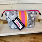 Olivia Small Neoprene Makeup Bag: gray camo, pink/orange stripes, pink zipper, "HELLO THERE! olivia" tag. Available in small size.