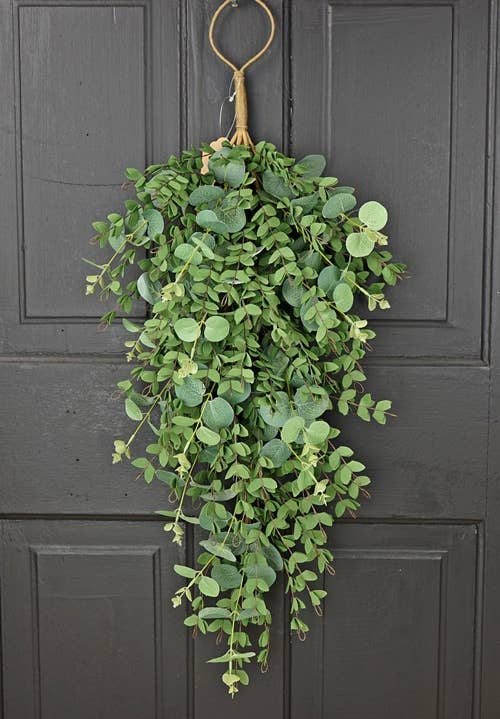 This product is a 29 inch Teardrop-Mixed Eucalyptus wreath in lush green color. It features a gold ring for hanging. Ideal for enhancing door decor with a natural touch.