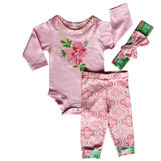 Three piece set with long sleeved pink onesie with flower on chest, pink geometic design pants, and green headband with pink geometric design bow.