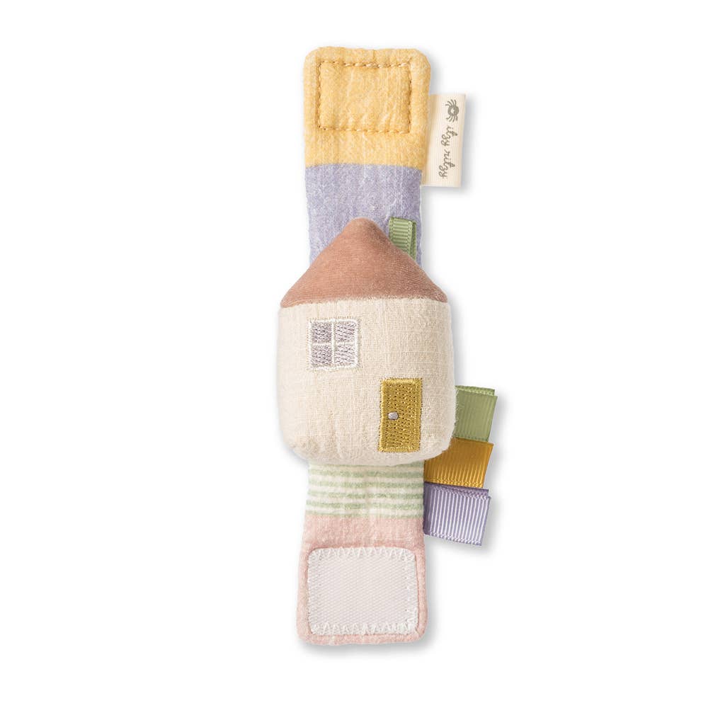 Soft baby toy designed as an Itzy Bitzy Wrist Rattle: Cottage with various natural cotton fabric patterns and labels, isolated on a white background.