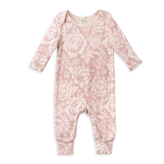 Long sleeve baby romper with snap closure. Cream floral design on a pink base.