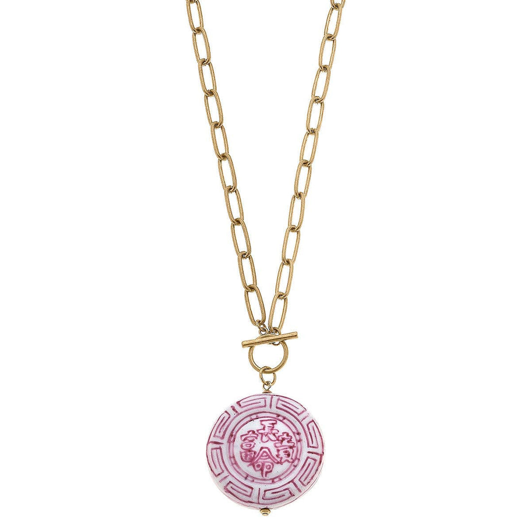 Gold chain with elongated links, toggle clasp, pink and white round pendant with patterns. Available in 16", 18", and 20".