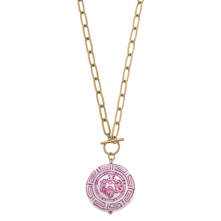 Gold chain with elongated links, toggle clasp, pink and white round pendant with patterns. Available in 16", 18", and 20".