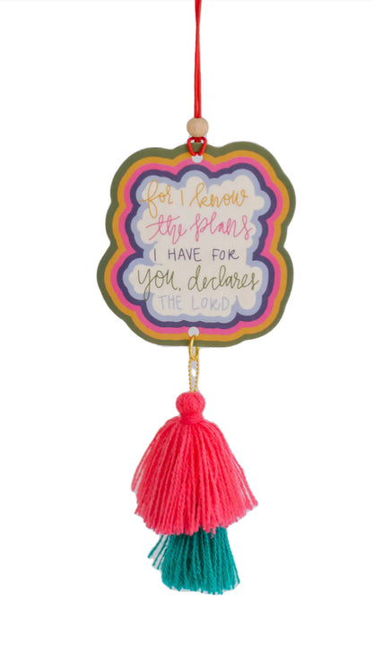 This is a colorful Air Freshener releasing a pleasant fragrance. Featuring the inspirational quote "for I know the plans I have for you, declares the Lord", it is accented with layers of vibrant colors and adorned with a red and green tassel at the bottom. Available in one standard size.