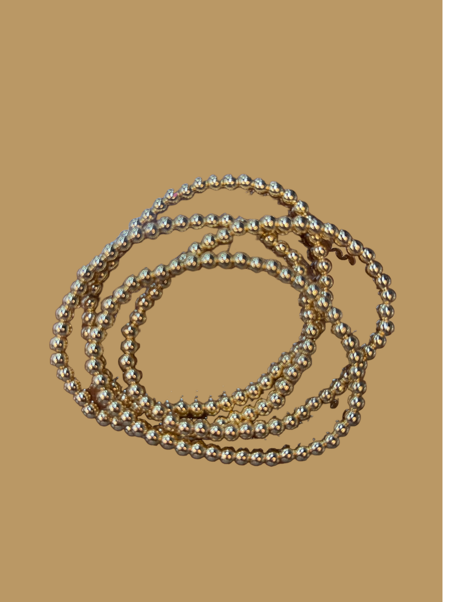 The product is an 18 K Gold Filled Bead Bracelet collection with shimmering accents. Available sizes for the bracelets are not specified.