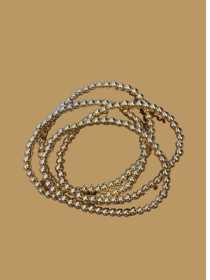 The product is an 18 K Gold Filled Bead Bracelet collection with shimmering accents. Available sizes for the bracelets are not specified.