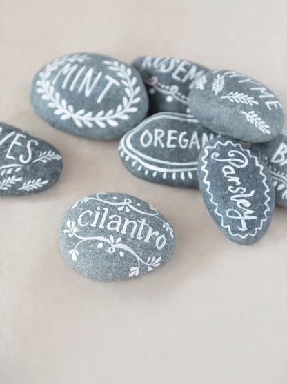 Smooth gray stones, hand-lettered with herb names in white. Available sizes: Small, Medium, Large.