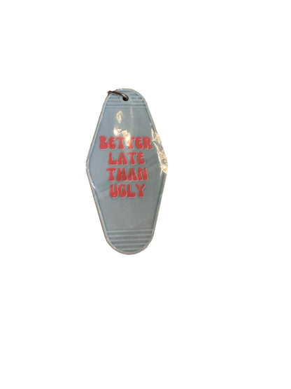 Light blue retro motel keychain with "BETTER LATE THAN UGLY" in bold pink letters. Available sizes: small, medium, large.