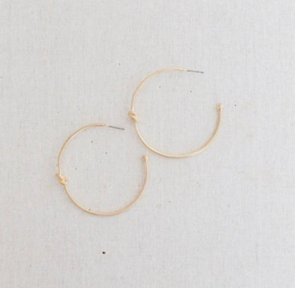 Simple gold hoop earrings with a small knot detail. Available sizes: small, medium, large.