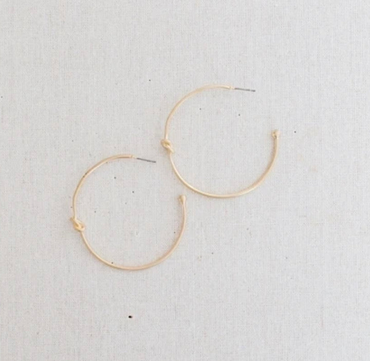 Simple gold hoop earrings with a small knot detail. Available sizes: small, medium, large.