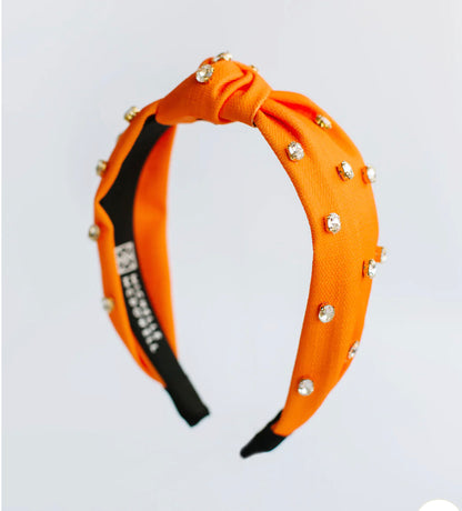 Orange fabric headband with knotted top, small rhinestones; available in S, M, and L.