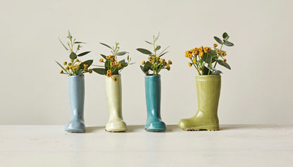 Set of four stoneware boot vases with green foliage and yellow flowers. Available in small, medium, and large sizes.