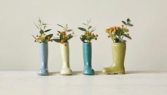 Set of four stoneware boot vases with green foliage and yellow flowers. Available in small, medium, and large sizes.