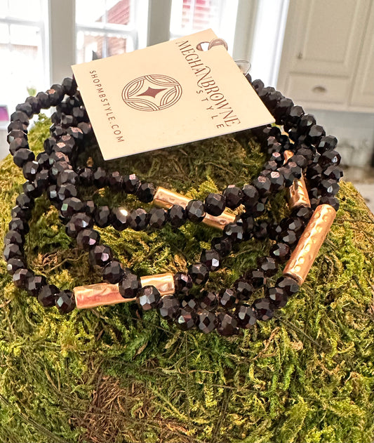 Three faceted black IVA Bracelets with shiny gold tube accents. Available sizes: S, M, L. Megan Browne Style tag attached.