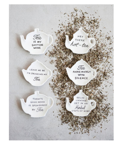 Set of six white stoneware teapot-shaped plates with tea-themed phrases. Available in 5-inch size.