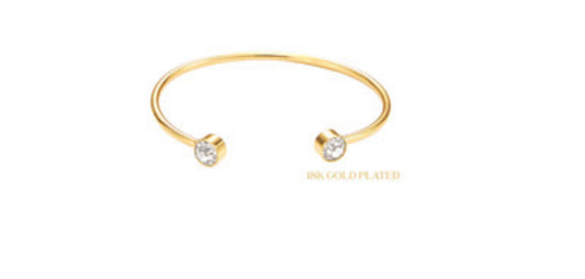 The product is an 18K Gold Plated Round Cuff featuring Clear Crystal End Accents. It is delicately designed to elegantly adorn your wrist. The cuff's size can be adjusted to fit comfortably.