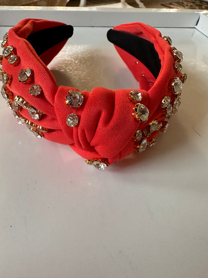 Wide, bright red knotted headband with large clear rhinestones in gold settings. Available in sizes S, M, L.