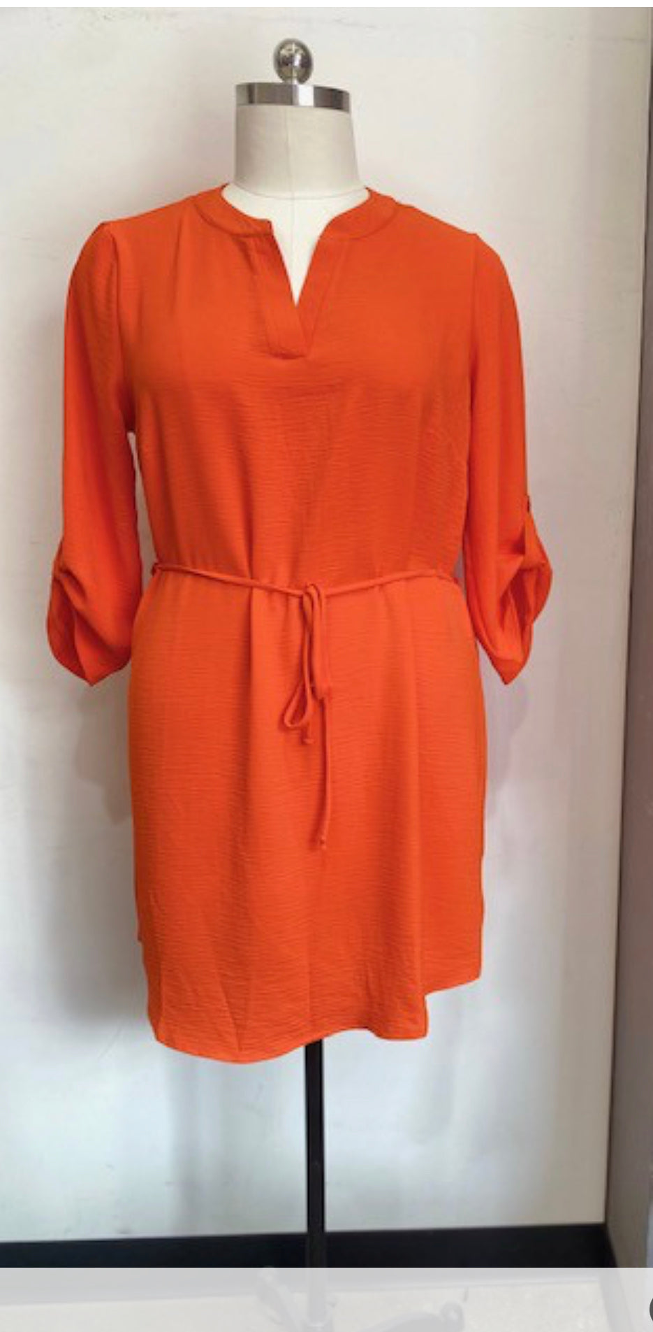 The Always Dress is a vibrant orange in color, featuring stylish three-quarter sleeves and a trendy tie waist detail. It comes in sizes ranging from small to extra large.