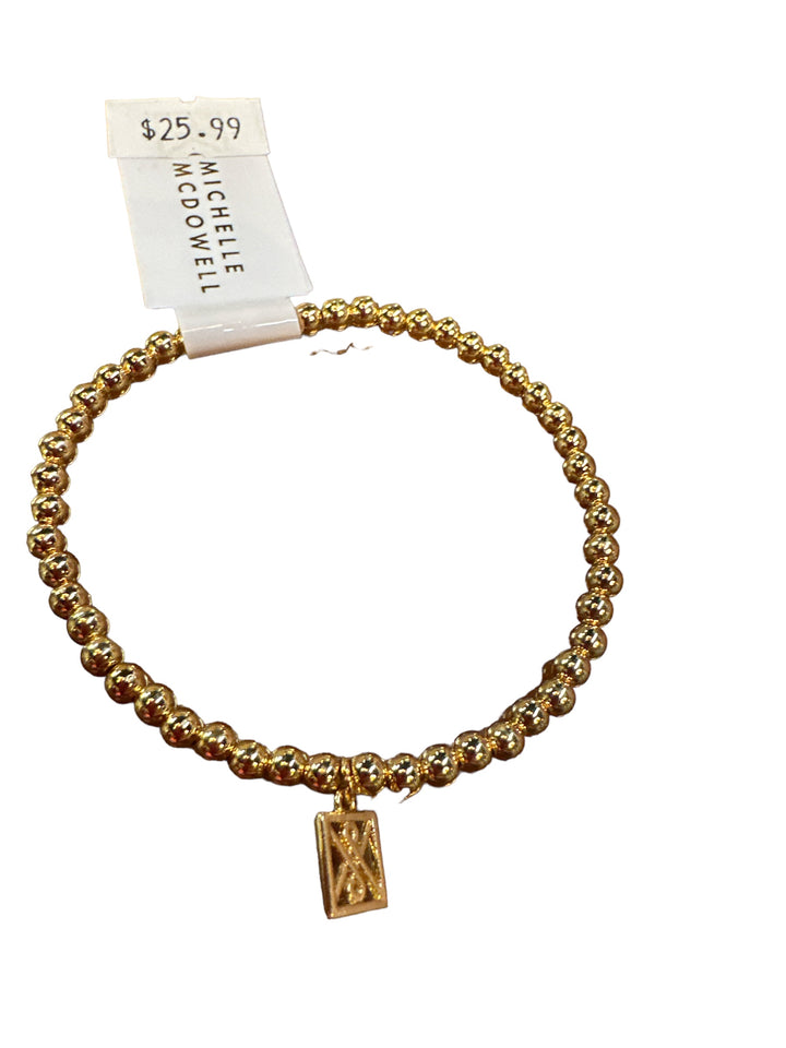 Shiny Gold Bracelet with gold beads and a rectangular charm. Sizes available: S, M, L. Price: $25.99. Brand: Michelle McDowell.
