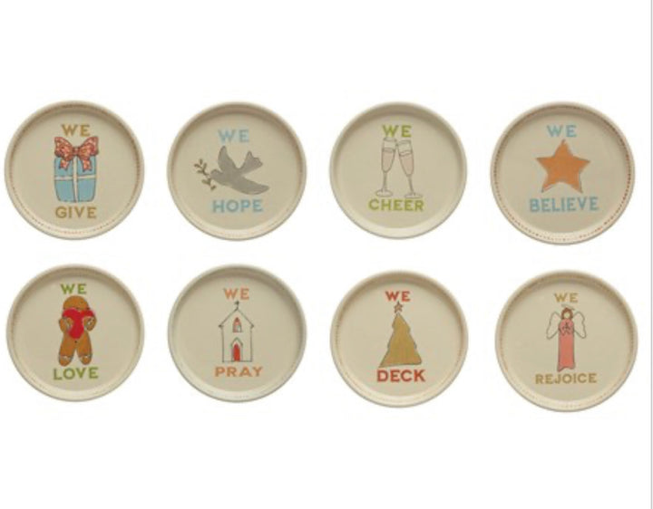 Set of eight 5″ round stoneware holiday icon plates featuring the word “WE” and thematic verbs.