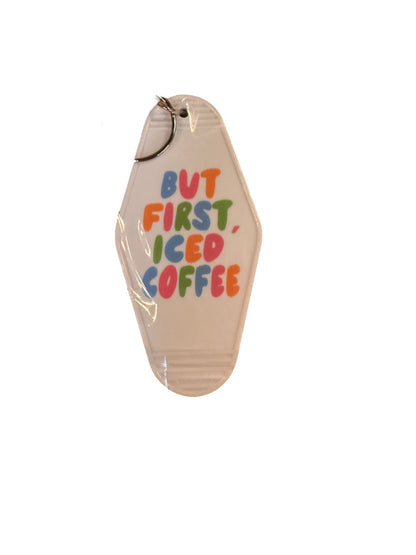White Retro Motel Keychain with "BUT FIRST, ICED COFFEE" in colorful letters, silver key ring. Sizes: standard.