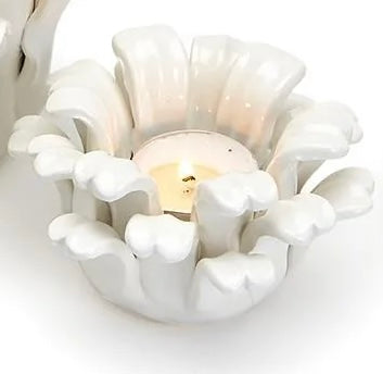 White ceramic tea light holder shaped like an open flower, petal-like edges. Sizes available: small, medium, large.