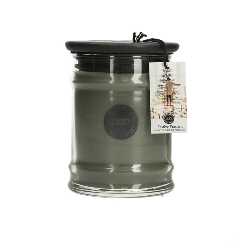 Festive Frasier 8.5 oz green candle in clear jar with black lid, tree tag. Fresh fir scent. Burns up to 70 hours.
