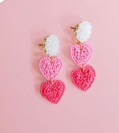 Michelle McDowell Earrings with beaded white tops and two pink heart-shaped dangles; available in one size.