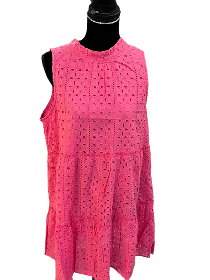 Sleeveless bright pink cotton dress with eyelet embroidery, high neckline, ruffle hem, tiered design. Available in sizes XS–XL.