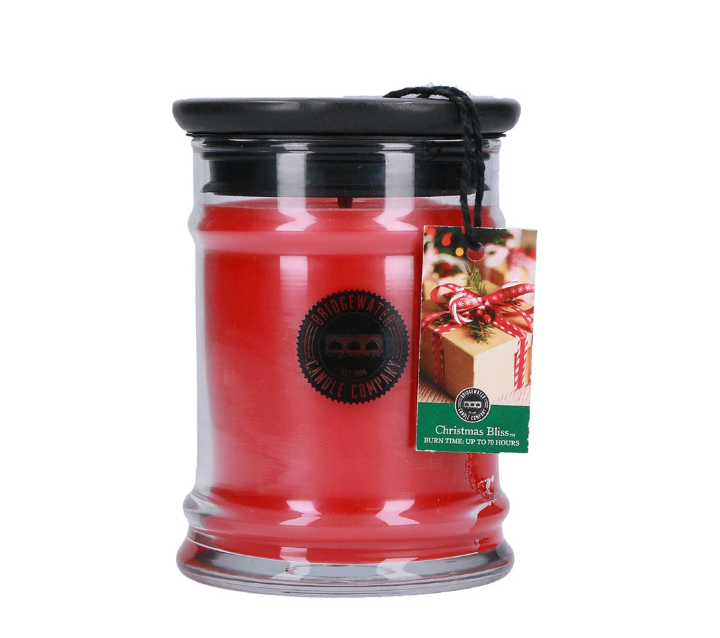 Red Christmas Bliss jar candle with a black lid and hanging gift-wrapped box tag.