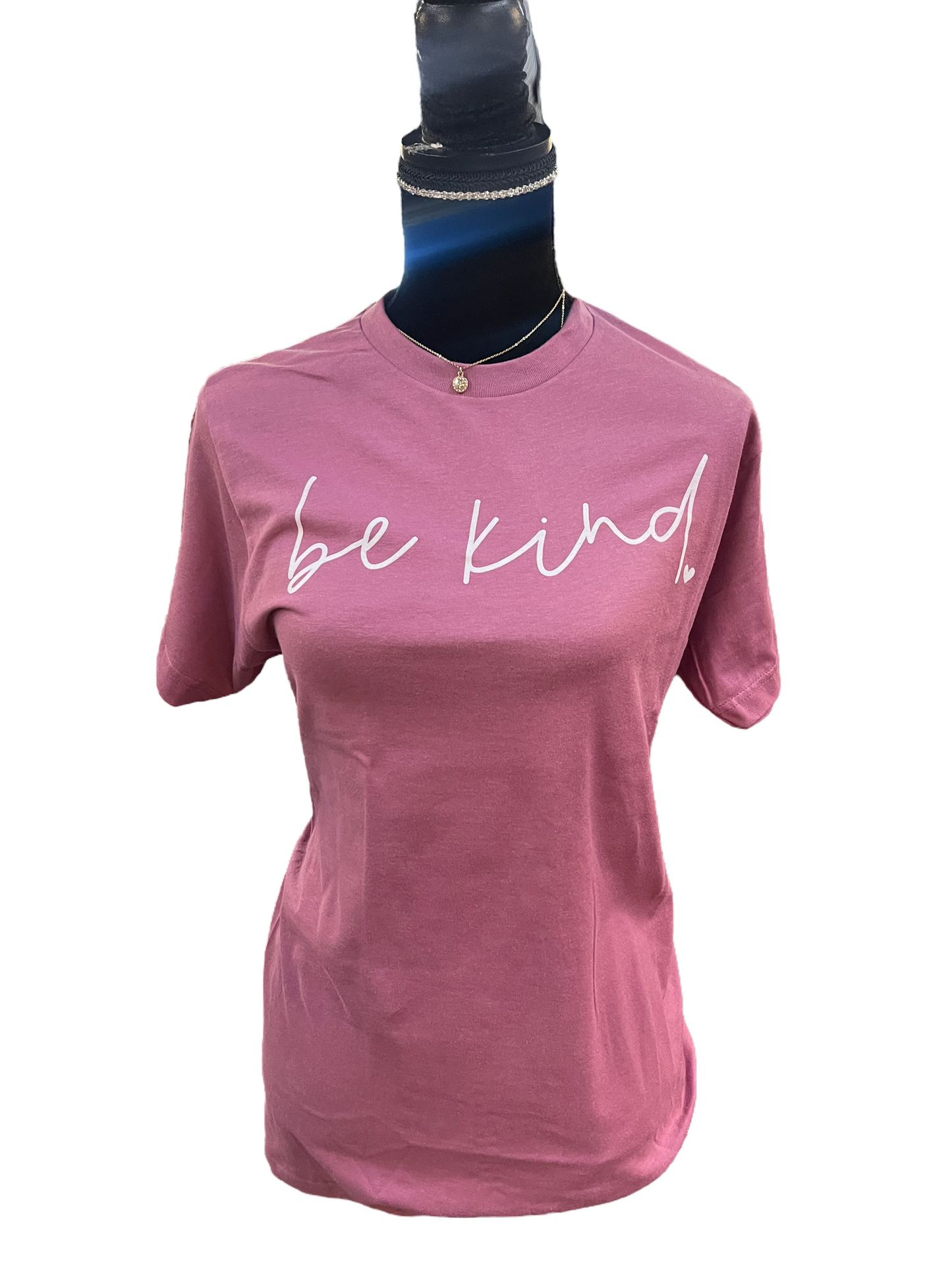 A pink Tultex 202 t-shirt displayed on a mannequin with the Be Kind T Shirt - Mauve written in white cursive on the front.