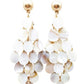 Chandelier-style Mira Earrings with layered iridescent shell discs on gold studs, 3 inches long. One size available.