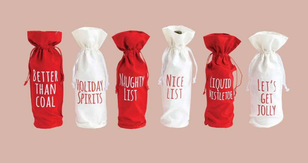 Six red or white fabric drawstring wine bags featuring holiday sayings: “Better Than Coal,” “Holiday Spirits,” “Naughty List,” “Nice List,” “Liquid Mistletoe,” and “Let’s Get Jolly.”.