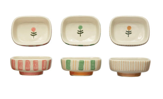 Set of six small rectangular hand-painted stoneware dishes with floral and geometric designs in red, green, and yellow. Sizes vary.