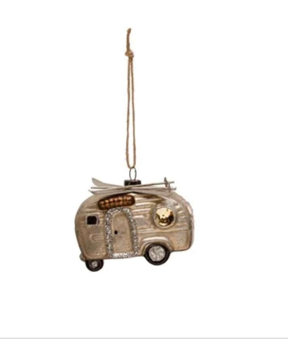 Gold, vintage-style glass camper ornament with roof-mounted skis and twine loop.