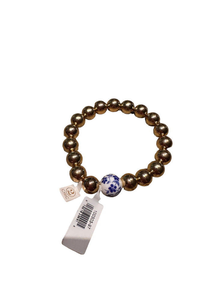 Chinoiserie Chic Stretch Bracelet with shiny gold beads, one white bead with blue floral patterns. Sizes available: S, M, L.