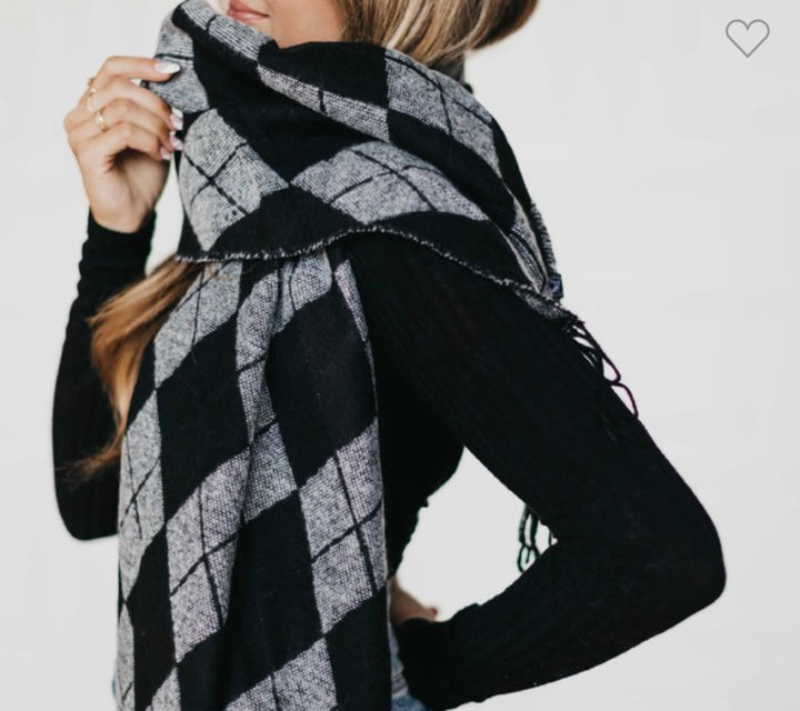 Argyle Scarf in black and gray, shown wrapped around neck and mouth. Available in sizes S, M, L.