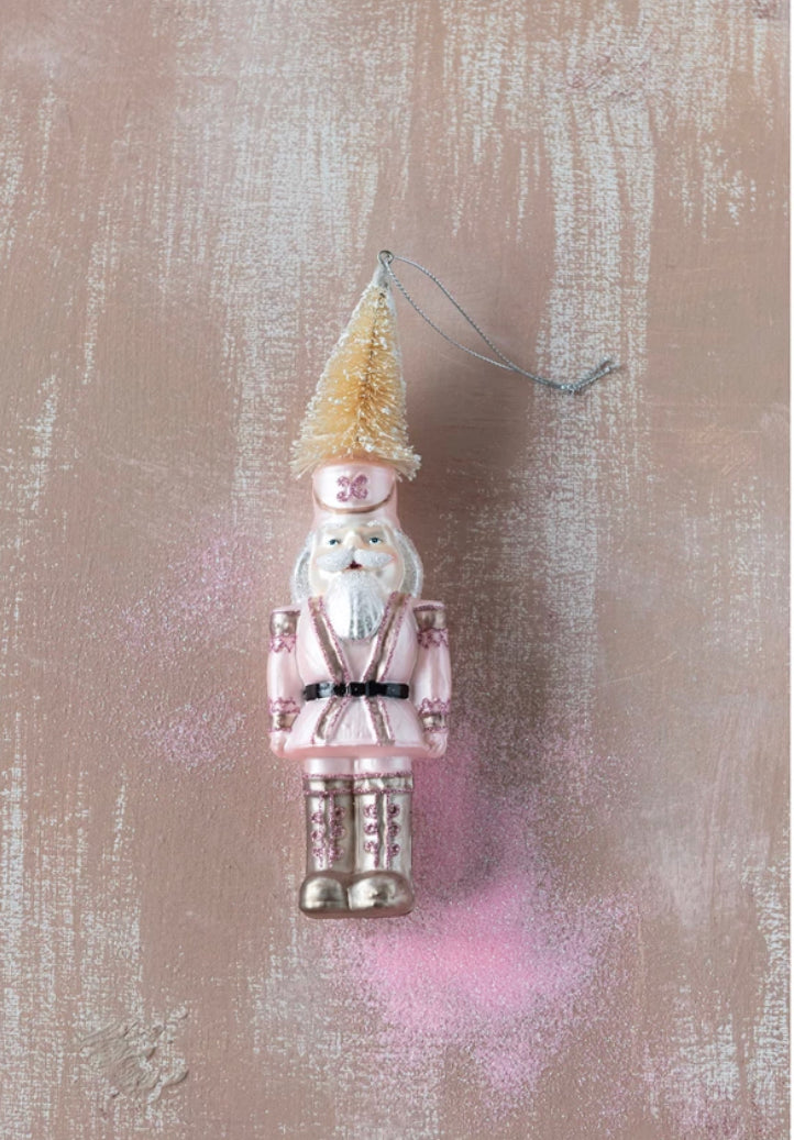 Pink hand-painted glass soldier ornament with bottle brush hat and silver accents.